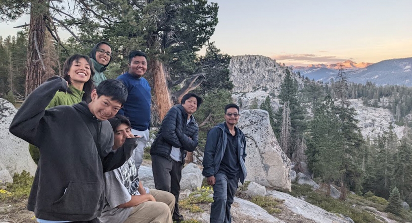 a group of students pose for a photo in the high sierra while on a backpacking trip with outward bound